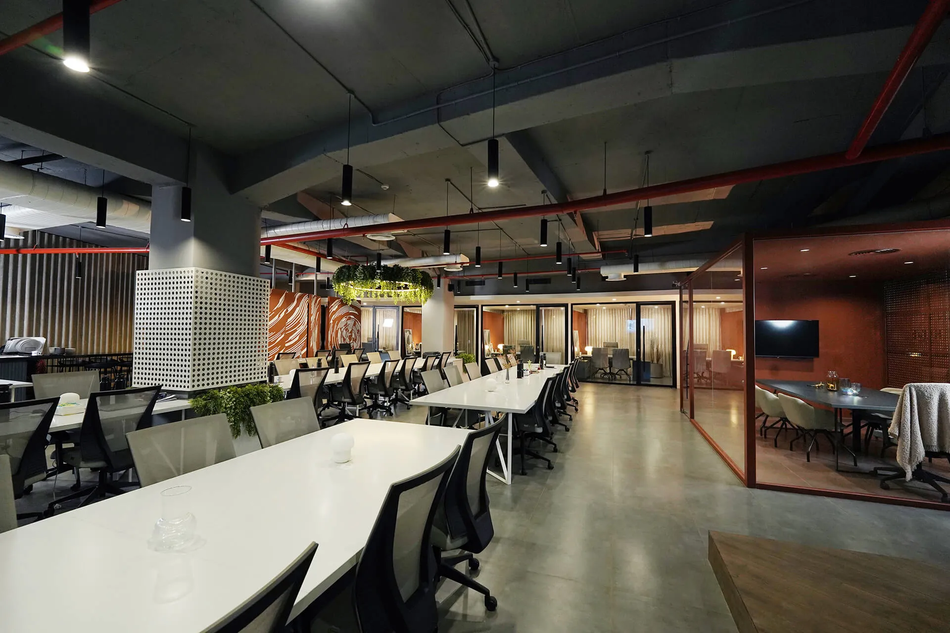 A modern office interior showcasing multiple tables and chairs positioned centrally for teamwork and meetings