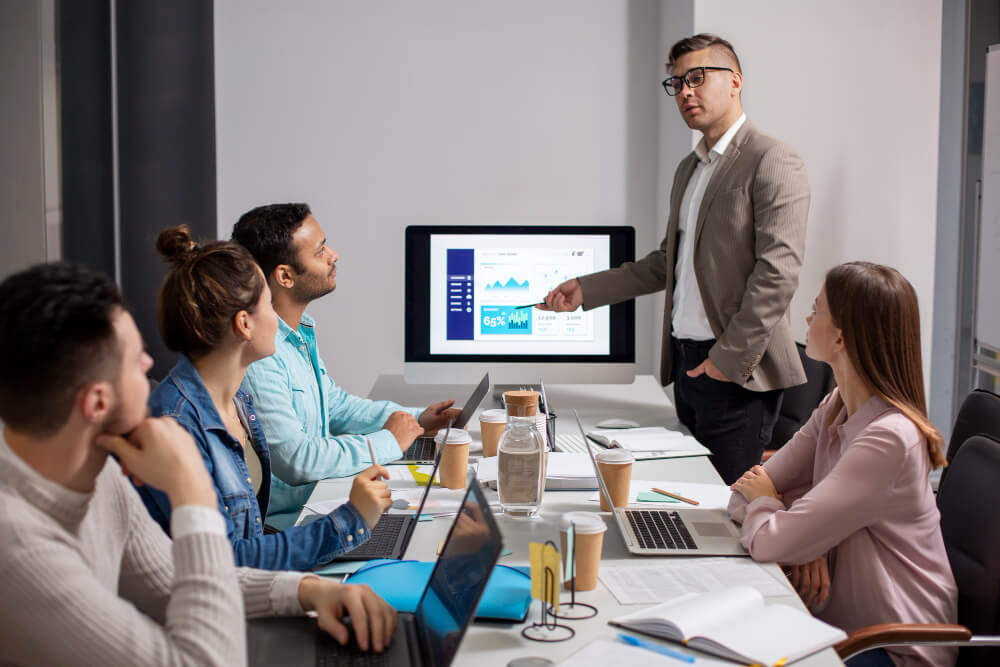 A speaker discusses online personal finance courses while addressing a diverse audience during a presentation.