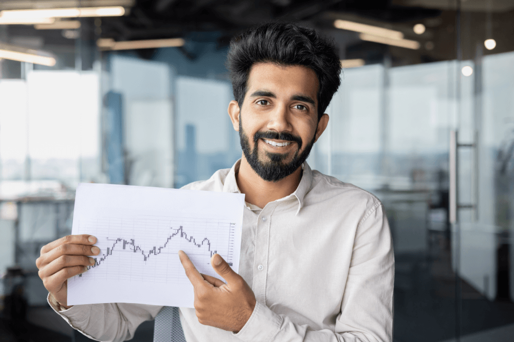 A happy trader showing a chart from a Forex trading course in Malayalam.